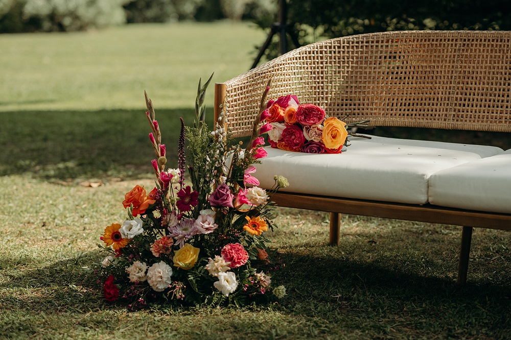 Décoration florale colorée placée devant une banquette de mariage