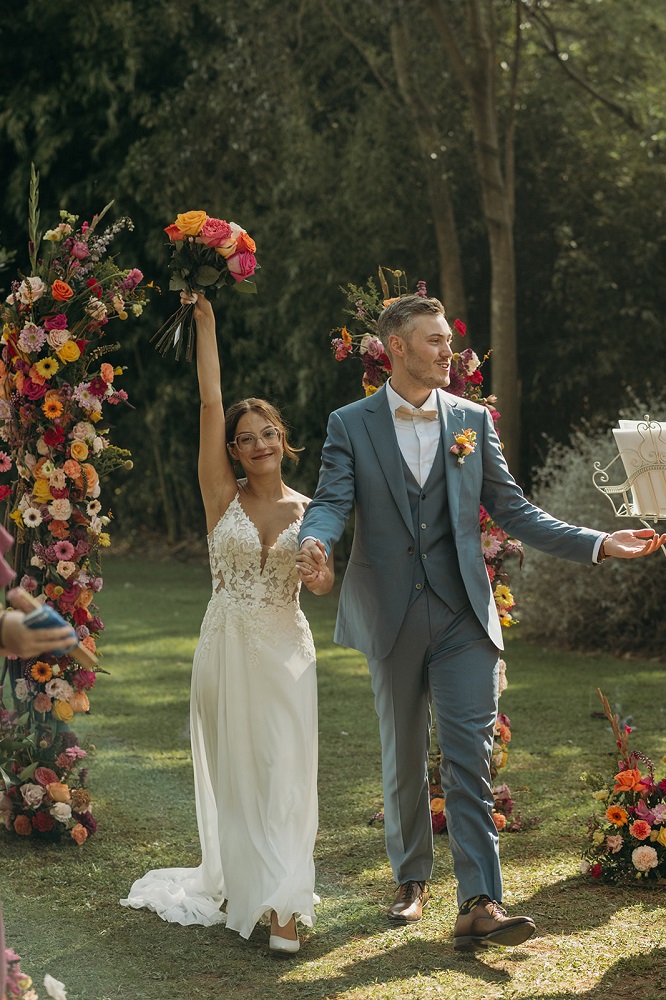 Mariée qui tient son bouquet en hauteur à la cérémonie