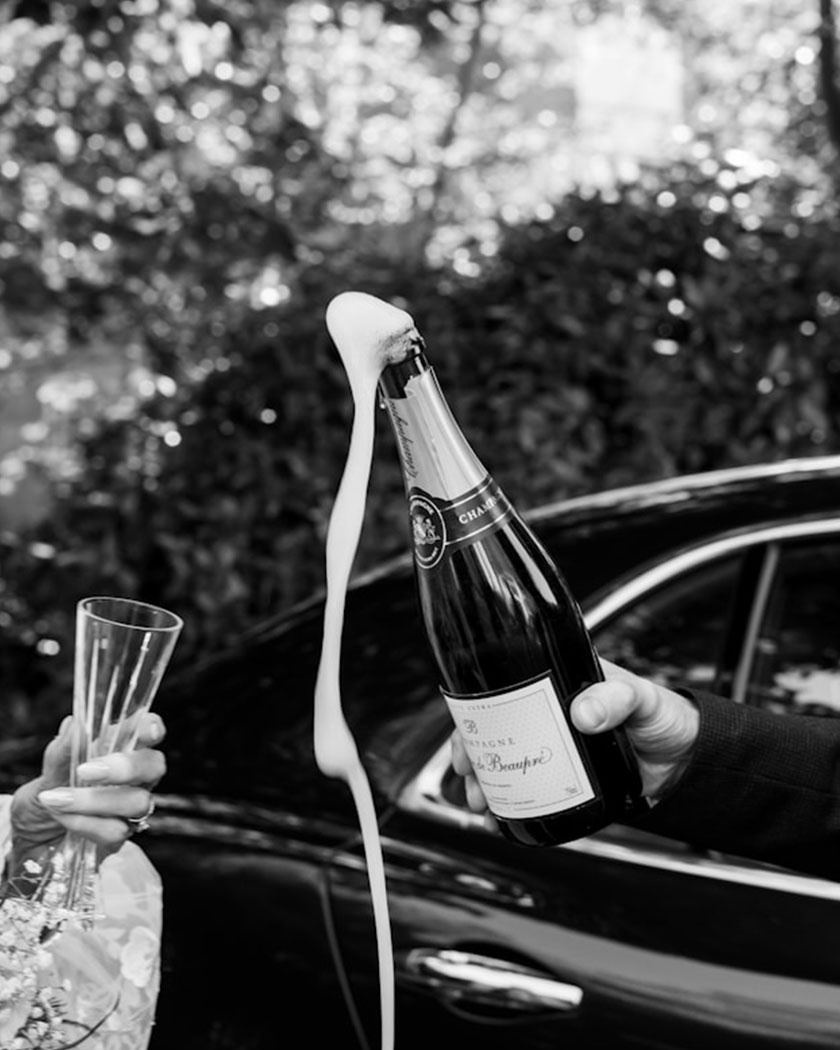 couple détendu trinquant lors de leur arrivée à la reception car leur wedding planner veille à ce que tout se passe comme prévu