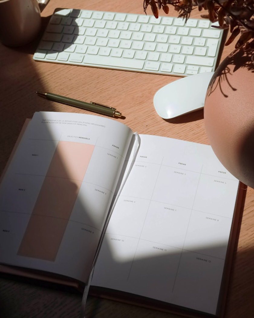 rétroplanning de mariage annoté posé près d'un agenda et d'un stylo